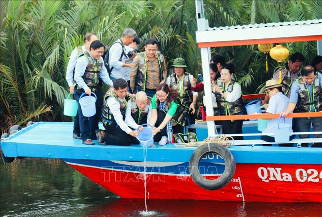 Các đại biểu thả cá sau lễ kỷ niệm Ngày Quốc tế Đa dạng sinh học năm 2024. Ảnh: Trần Tĩnh - TTXVN