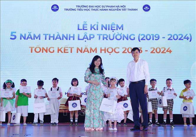 PGS.TS. Nguyễn Văn Hiền, Bí thư Đảng uỷ, Chủ tịch Hội đồng Trường Đại học Sư phạm Hà Nội trao khen thưởng cho học sinh giỏi của trường Tiểu học thực hành Nguyễn Tất Thành. Ảnh: Thanh Tùng - TTXVN