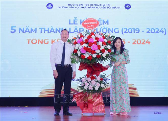 PGS.TS. Nguyễn Đức Sơn - Hiệu trưởng Trường Đại học Sư phạm Hà Nội tặng hoa chúc mừng nhà trường trong Lễ kỷ niệm 5 năm thành lập trường và Tổng kết năm học 2023 - 2024. Ảnh: Thanh Tùng - TTXVN