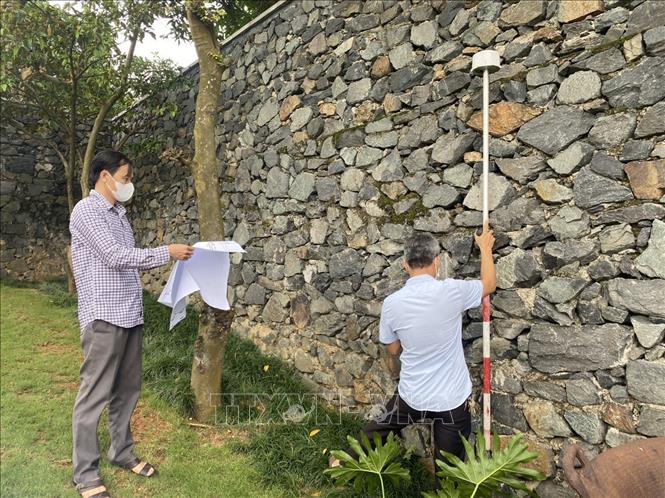 Cơ quan chức năng tỉnh Vĩnh Phúc tiến hành đo đạc, cắm mốc thực địa diện tích đất bị lấn chiếm sử dụng trái phép. Ảnh: Nguyễn Thảo - TTXVN