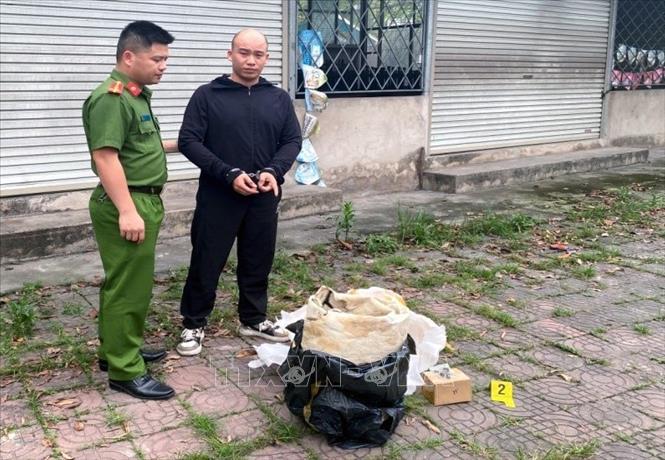 Đối tượng Nguyễn Huy Hoàng (phải) cùng tang vật bị Công an thành phố Uông Bí bắt giữ. Ảnh: TTXVN phát
