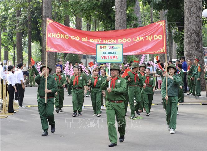 Đoàn diễu hành Đại đoàn Việt Bắc, tái hiện hình ảnh lực lượng phóng viên chiến trường, văn công trong Chiến dịch Điện Biên Phủ tại chương trình. Ảnh: Hồng Giang - TTXVN. 