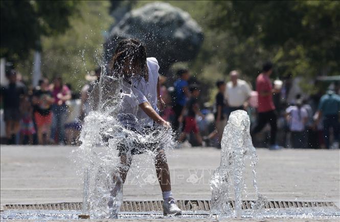 Một em nhỏ làm mát tại đài phun nước trong ngày nắng nóng ở Guadalajara, Mexico ngày 23/5/2024. Ảnh: AFP/TTXVN