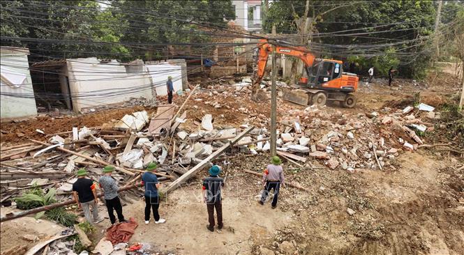 Lực lượng chức năng tháo dỡ công trình vi phạm để phục vụ cho dự án cải tạo, nâng cấp đường tỉnh lộ 414c, đoạn đi qua địa bàn xã Thuần Mỹ và xã Ba Trại, huyện Ba Vì. Ảnh: Vũ Sinh - TTXVN