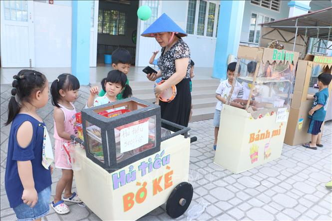 Trẻ em Trường Mầm non Sơn Ca (phường Tân Ngãi, thành phố Vĩnh Long, tỉnh Vĩnh Long) tham gia phiên chợ tại sân trường. Ảnh: Lê Thúy Hằng - TTXVN