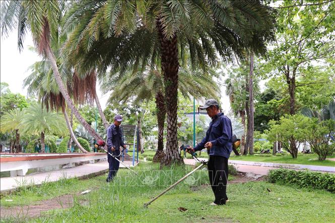 Công nhân chăm sóc cây xanh trong khuôn viên Công viên Văn hoá Hùng Vương. Ảnh: Kim Há -TTXVN
