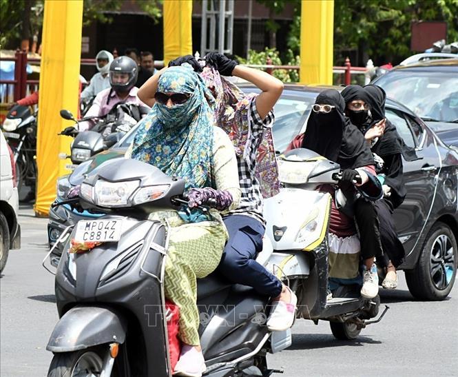 Người dân quấn khăn tránh nắng nóng khi di chuyển trên đường tại Bhopal, Ấn Độ ngày 27/5/2024. Ảnh: ANI/TTXVN