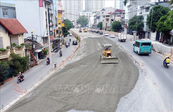 Các phương tiện máy móc san nền đường để kịp thảm nhựa. Ảnh: Tuấn Anh - TTXVN