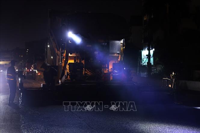Đơn vị thi công thảm nhựa mặt đường trong đêm để kịp thời đảm bảo tiến độ thông xe. Ảnh: Tuấn Anh - TTXVN