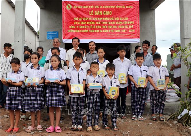Tại lễ trao nhà, các học sinh nghèo được tặng thêm tập vở. Ảnh: Trung Hiếu-TTXVN