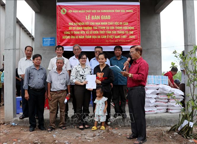 Lãnh đạo xã An Thạnh Nam, huyện Cù Lao Dung trao Quyết định tặng nhà Đại đoàn kết cho hộ ông Đặng Văn Dện. Ảnh: Trung Hiếu-TTXVN