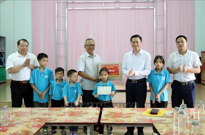 Phó Chủ tịch HĐND tỉnh Lạng Sơn Đinh Hữu Học (bên phải) tặng quà trẻ em có hoàn cảnh đặc biệt tại Trung tâm Hy Vọng Lộc Bình. Ảnh: Anh Tuấn – TTXVN