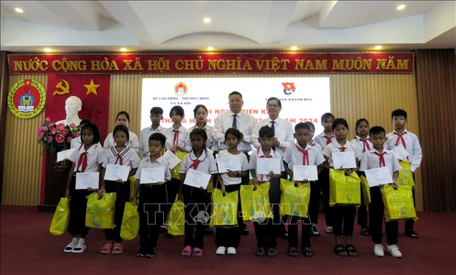 Chủ tịch UBND Khánh Hòa Nguyễn Tấn Tuân và Giám đốc Sở Giáo dục và Đào tạo Võ Hoàn Hải trao học bổng cho các học sinh. Ảnh: Phan Sáu - TTXVN                                          