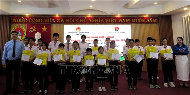 Giám đốc Sở Lao động Thương binh và Xã hội tỉnh Khánh Hòa Tạ Hồng Quang và Phó Bí thư Tỉnh đoàn Huỳnh Thị Như Ý trao học bổng cho các học sinh. Ảnh: Phan Sáu - TTXVN           