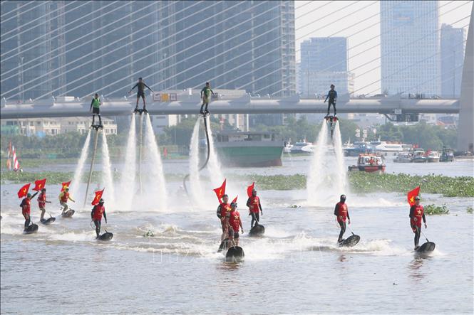 Các vận động viên chuyên nghiệp trình diễn bay bằng ván phản lực nước, lướt ván, Flyboard trên sông Sài Gòn. Ảnh: Thanh Vũ-TTXVN
