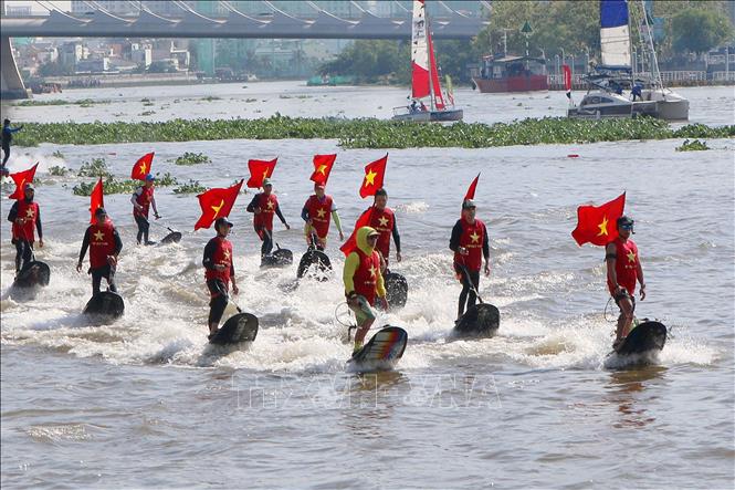 Các vận động viên chuyên nghiệp đồng diễn bay bằng ván phản lực nước trên sông Sài Gòn. Ảnh: Thanh Vũ-TTXVN
