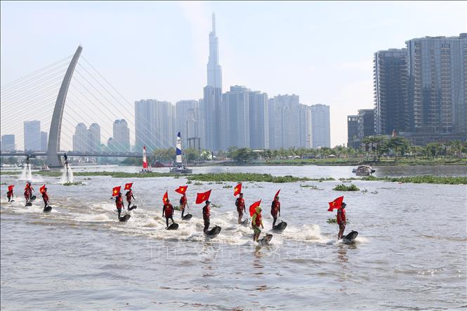 Các vận động viên chuyên nghiệp đồng diễn bay bằng ván phản lực nước trên sông Sài Gòn. Ảnh: Thanh Vũ-TTXVN
