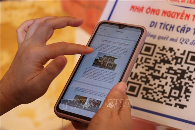 Du khách quét QR để tìm hiểu thông tin về ngôi biệt thự cổ. Ảnh: Minh Hưng - TTXVN