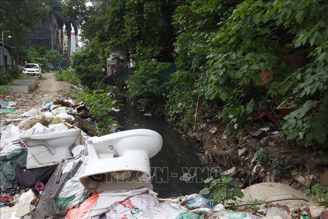 Rác thải bủa vây tràn xuống lòng mương thoát nước trên địa bàn phường Đội Cấn (quận Ba Đình). Ảnh: Huy Hùng - TTXVN
