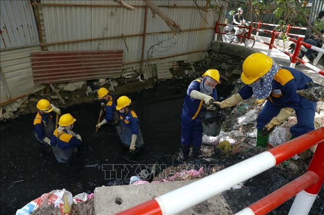 Công nhân Xí nghiệp Thoát nước số 2 nạo vét bùn đất, trục vớt rác thải để khơi thông dòng chảy tại khu vực mương thoát nước Dịch Vọng. Ảnh: Huy Hùng - TTXVN
