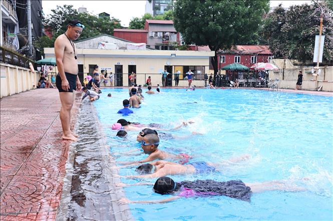 Huấn luyện viên hướng dẫn các động tác bơi đúng cách cho các em tại bể bơi Thái Hà. Ảnh: Minh Đức - TTXVN
