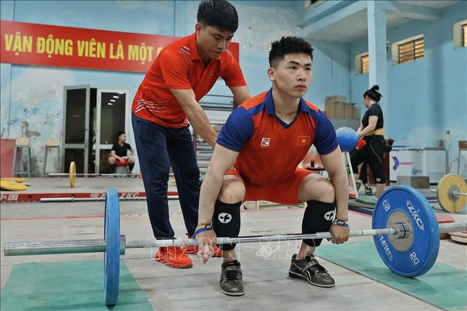 Huấn luyện viên trực tiếp Nguyễn Mạnh Thắng hướng dẫn kỹ thuật, tập trung cao độ cho đô cử Trịnh Văn Vinh. Ảnh: Minh Quyết – TTXVN
