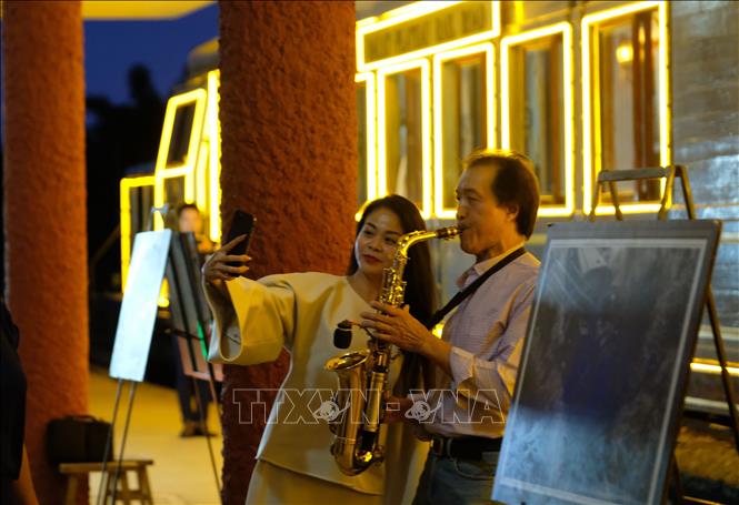 Du khách thích thú với màn trình diễn saxophone tại sân ga Đà Lạt trước giờ tàu hỏa khởi hành. Ảnh: Nguyễn Dũng – TTXVN