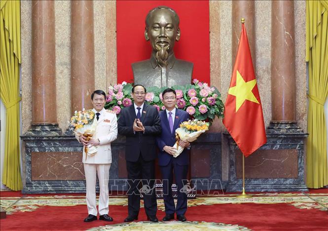 Phó Chủ tịch Quốc hội Trần Quang Phương chúc mừng Phó Thủ tướng Lê Thành Long và Bộ trưởng Bộ Công an Lương Tam Quang. Ảnh: Nhan Sáng-TTXVN