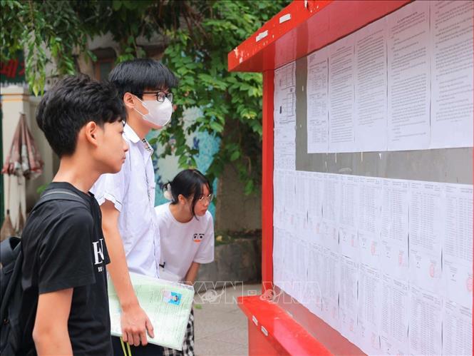Các thí sinh xem danh sách phòng thi tại điểm thi Trường THPT Thăng Long (quận Hai Bà Trưng). Ảnh: Hoàng Hiếu – TTXVN