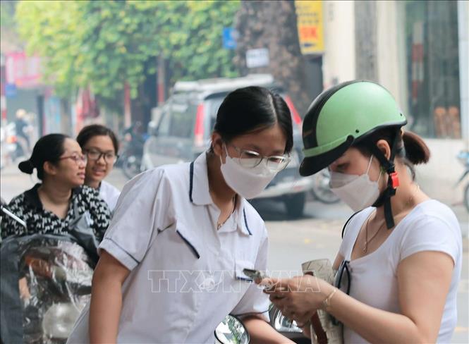 Phụ huynh và thí sinh trước giờ vào làm thủ tục dự thi tại điểm thi Trường THPT Thăng Long (quận Hai Bà Trưng). Ảnh: Hoàng Hiếu - TTXVN
