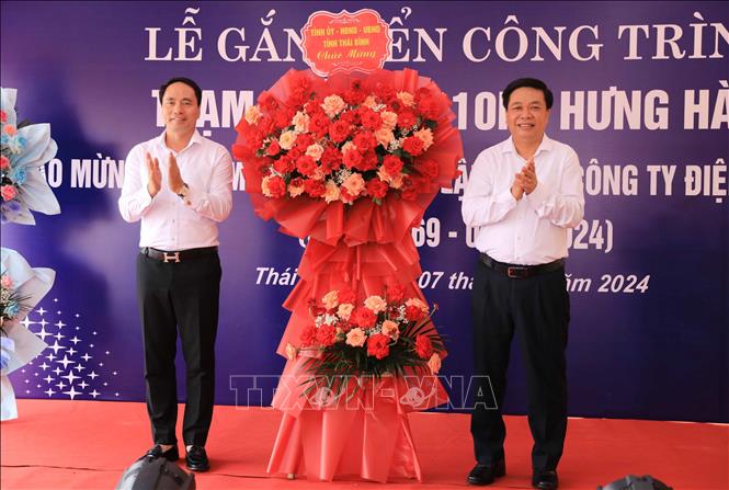 Phó Chủ tịch Thường trực UBND tỉnh Thái Bình Nguyễn Quang Hưng (bên phải) tặng hoa chúc mừng Tổng công ty Điện lực miền Bắc. Ảnh: Thế Duyệt – TTXVN