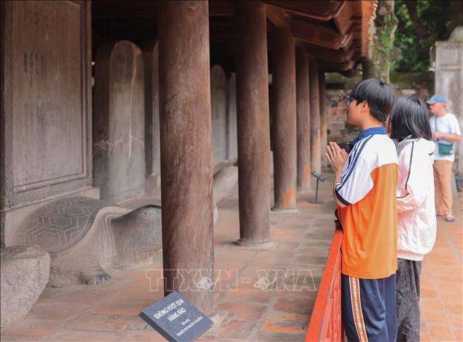 Thí sinh cầu may mắn tại khu vực Bia Tiến sĩ Di tích quốc gia đặc biệt Văn Miếu - Quốc Tử Giám. Ảnh: Hoàng Hiếu – TTXVN