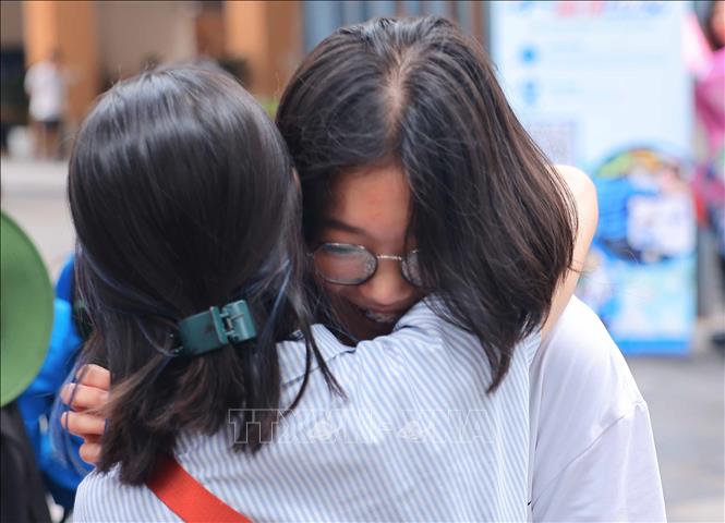 Phụ huynh và thí sinh chia sẻ niềm vui tại điểm thi Trường THCS Ngô Sĩ Liên, quận Hoàn Kiếm sau khi hoàn thành môn thi Ngữ văn. Ảnh: Hoàng Hiếu - TTXVN