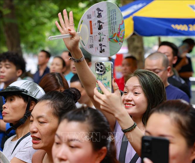 Phụ huynh đón thí sinh sau khi hoàn thành môn thi đầu tiên tại điểm thi Trường THPT Trần Nhân Tông, quận Hai Bà Trưng. Ảnh: Thanh Tùng - TTXVN 
