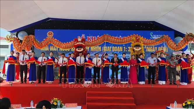 Các đại biểu thực hiện nghi thức cắt băng khánh thành nhà máy. Ảnh: Sỹ Thắng - TTXVN
