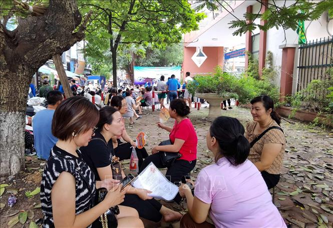 Phụ huynh chờ đón thí sinh thi môn Ngoại ngữ bên ngoài điểm thi Trường THPT Trương Định, quận Hoàng Mai. Ảnh: Thanh Tùng - TTXVN 