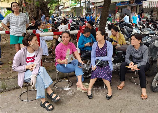 Phụ huynh chờ đón thí sinh thi môn Ngoại ngữ bên ngoài điểm thi Trường THPT Trương Định, quận Hoàng Mai. Ảnh: Thanh Tùng - TTXVN 
