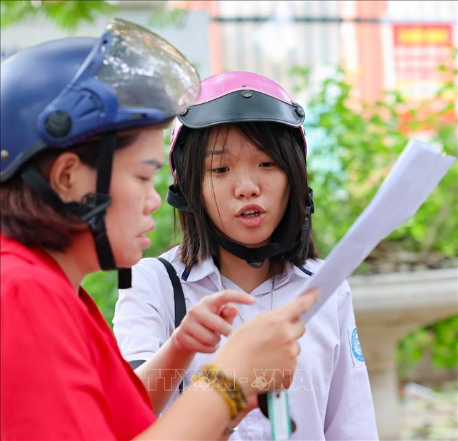 Thí sinh trao đổi với mẹ về bài làm môn Ngoại ngữ. Ảnh: Thanh Tùng - TTXVN