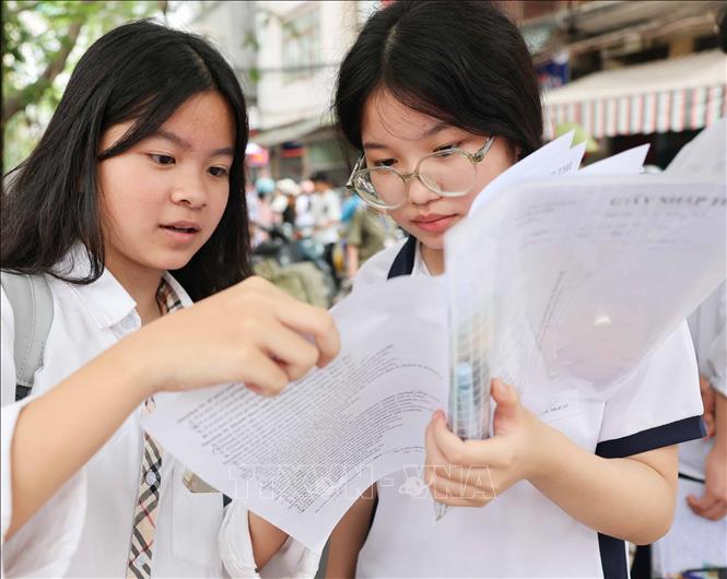Thí sinh cùng trao đổi về bài làm môn Ngoại ngữ. Ảnh: Thanh Tùng - TTXVN