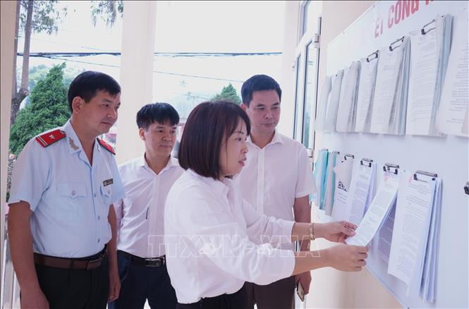 Lãnh đạo huyện Trấn Yên kiểm tra niêm yết tài liệu Dự thảo Đề án sắp xếp đơn vị hành chính tại trụ sở xã Đào Thịnh. Ảnh: Tuấn Anh - TTXVN