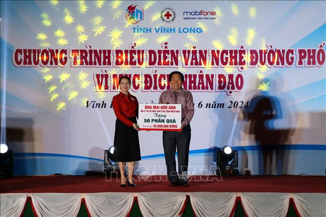 Lãnh đạo Hội Chữ thập đỏ tỉnh Vĩnh Long tiếp nhận ủng hộ của các nhà hảo tâm. Ảnh: Phạm Minh Tuấn-TTXVN