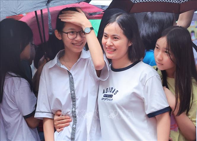 Niềm vui của mẹ và con sau khi kết thúc tốt đẹp môn thi cuối cùng của Kỳ thi. Ảnh: Hoàng Hiếu-TTXVN