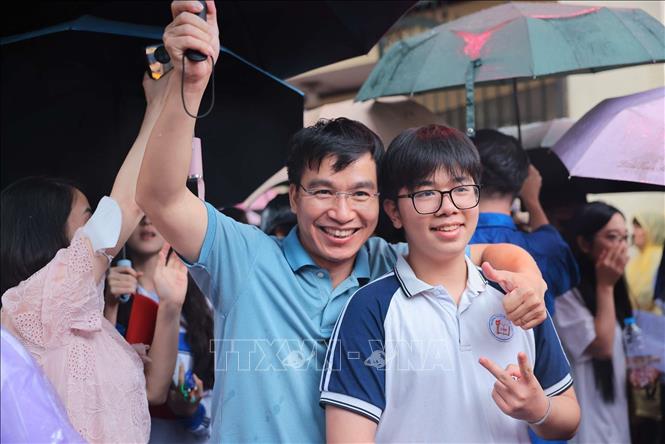 Bố đón và chia sẻ niềm vui với con trai sau khi hoàn thành tốt đẹp môn thi cuối cùng tại điểm thi Trường THPT Việt Đức, quận Hoàn Kiếm. Ảnh: Hoàng Hiếu - TTXVN