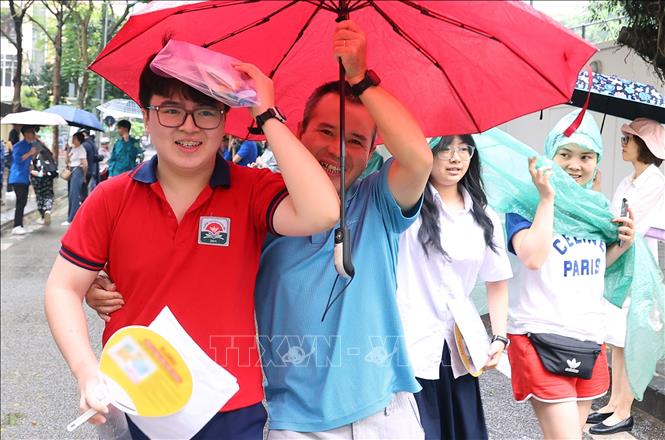Niềm vui của hai bố con tại điểm thi TrườngTHCS Thăng Long, quận Ba Đình. Ảnh: Văn Điệp – TTXVN