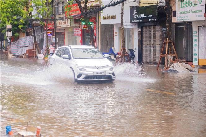 Việc đi lại của người dân gặp nhiều khó khăn do đường bị ngập lụt. Ảnh: Vũ Quang – TTXVN