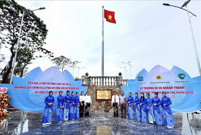 Đại biểu chụp ảnh lưu niệm dưới chân cột cờ. Ảnh: TTXVN phát