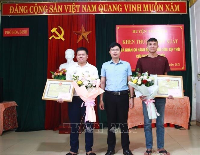 UBND huyện Tiên Yên (Quảng Ninh) biểu dương, khen thưởng đột xuất 2 nam thanh niên vì dũng cảm cứu người.  Ảnh: TTXVN phát 