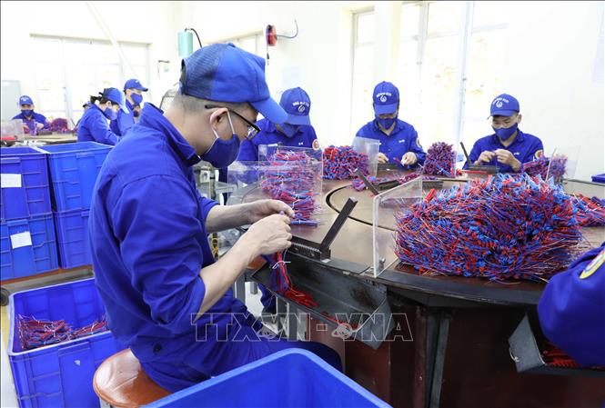 Công nhân hoàn thiện khâu xoắn dây kích nổ cho các giàn pháo hoa. Ảnh: Tạ Toàn – TTXVN