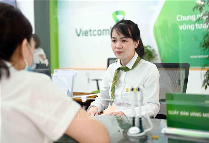 Khách hàng giao dịch nhận vàng sau khi đăng ký online tại Vietcombank 72 Trần Hưng Đạo, Hà Nội. Ảnh: Trần Việt - TTXVN