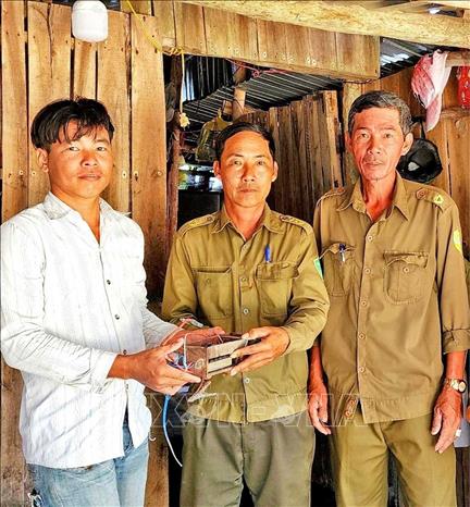 Người dân tự nguyện giao nộp xiệc điện cho ngành chức năng địa phương. Ảnh: TTXVN phát 